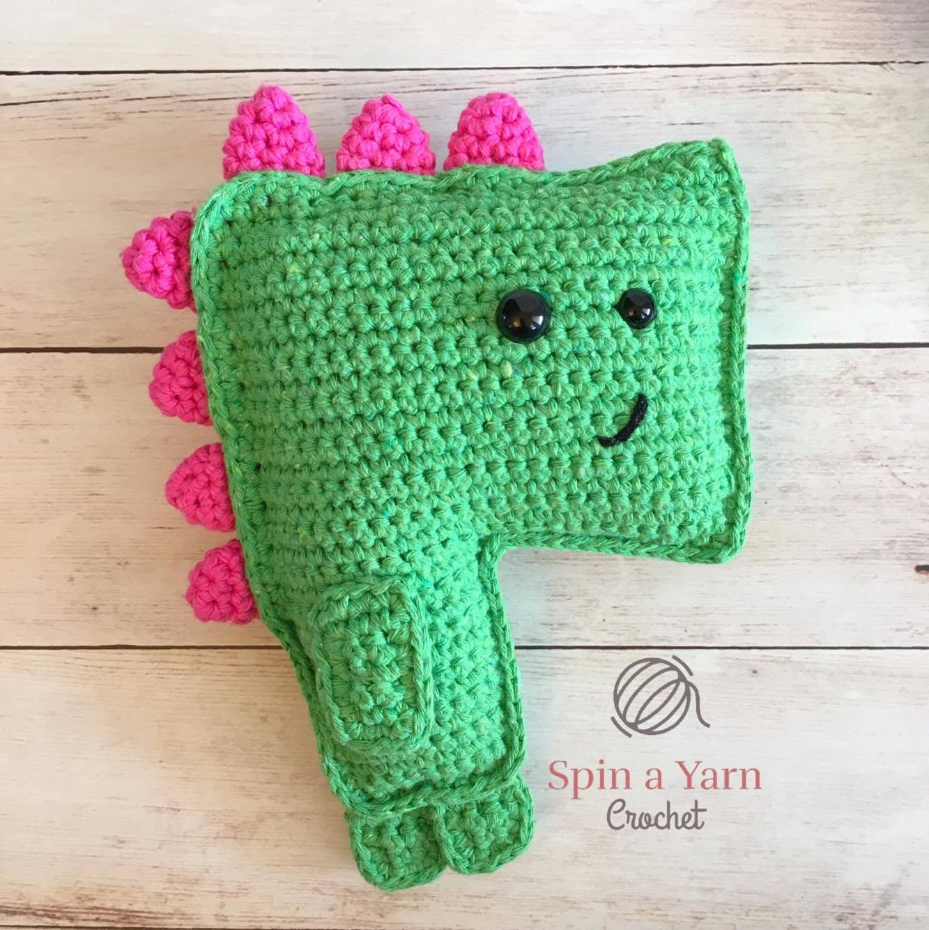 Crocheted green dinosaur body panel showing snout, back curve, and tail