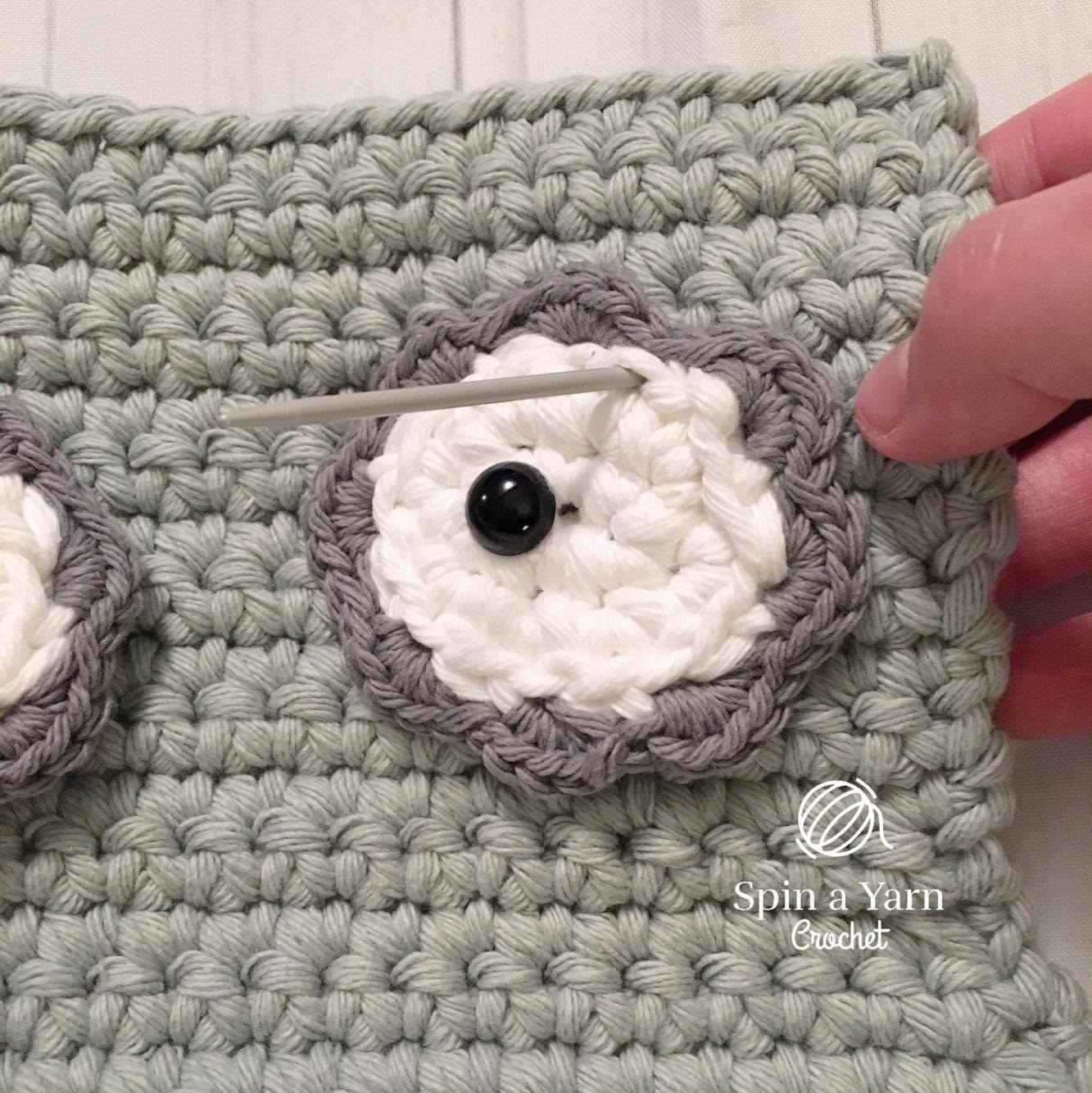 Whipstitching eye patches and beak onto front grey body panel