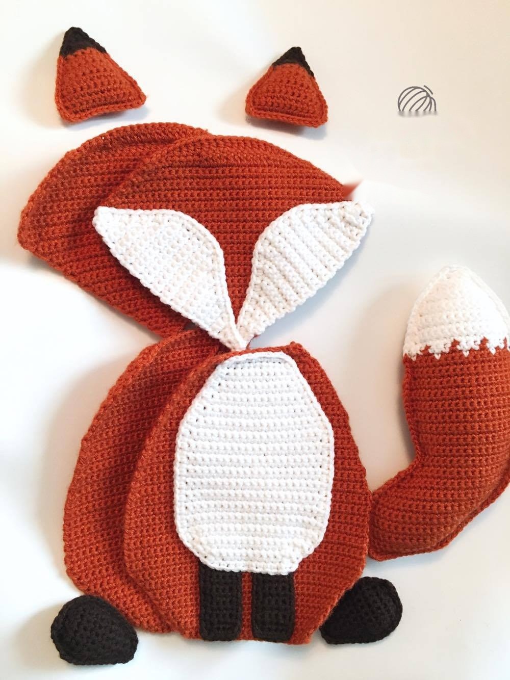 Single crocheting fox panels together, inserting paws, ears, and tail