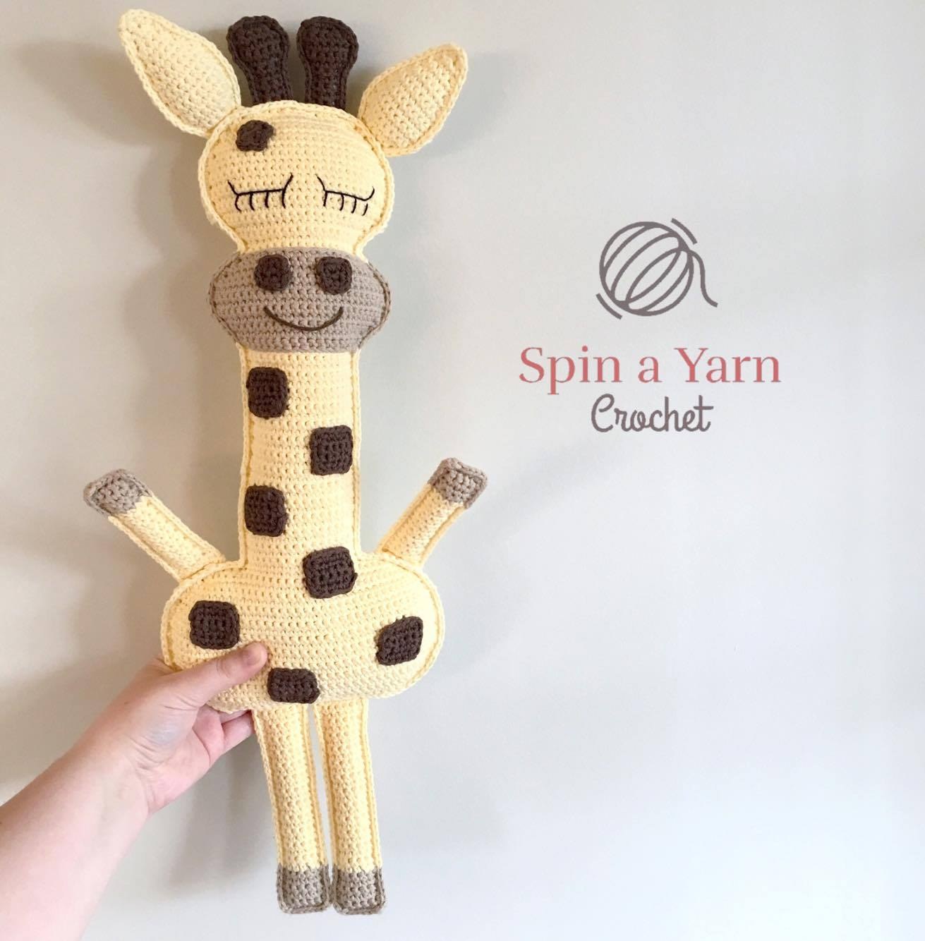 Finished crochet ragdoll giraffe amigurumi with brown spots on craft table