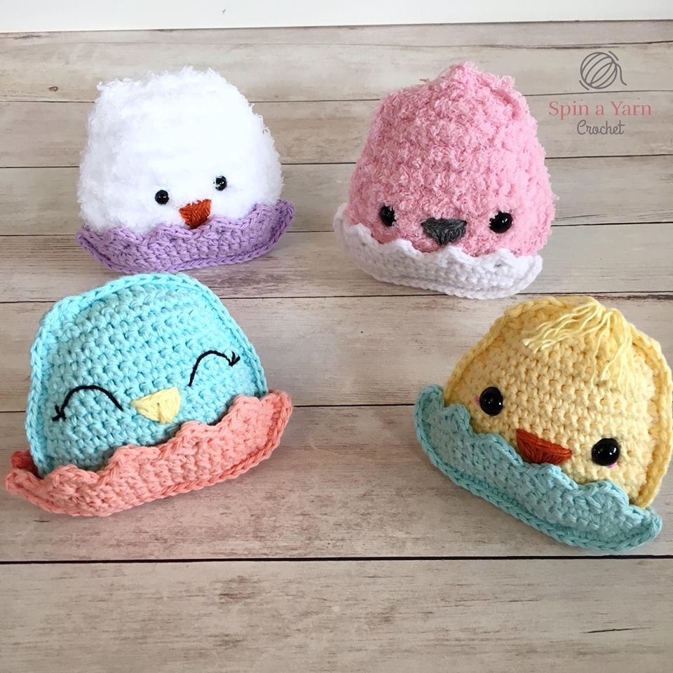 Four chubby crochet chicks sitting in eggshells