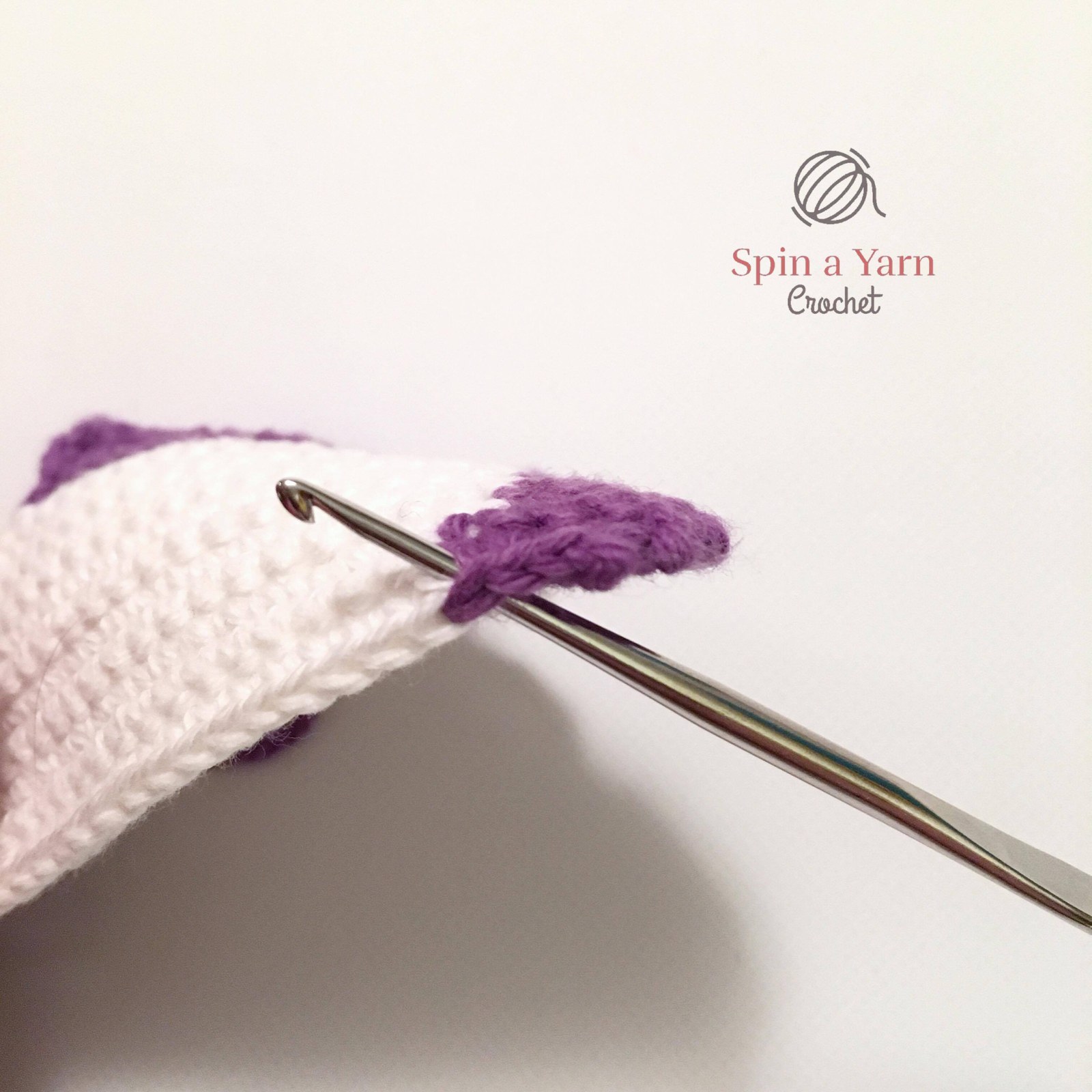 Hook inserted into stitch to rejoin yarn on snowman panel