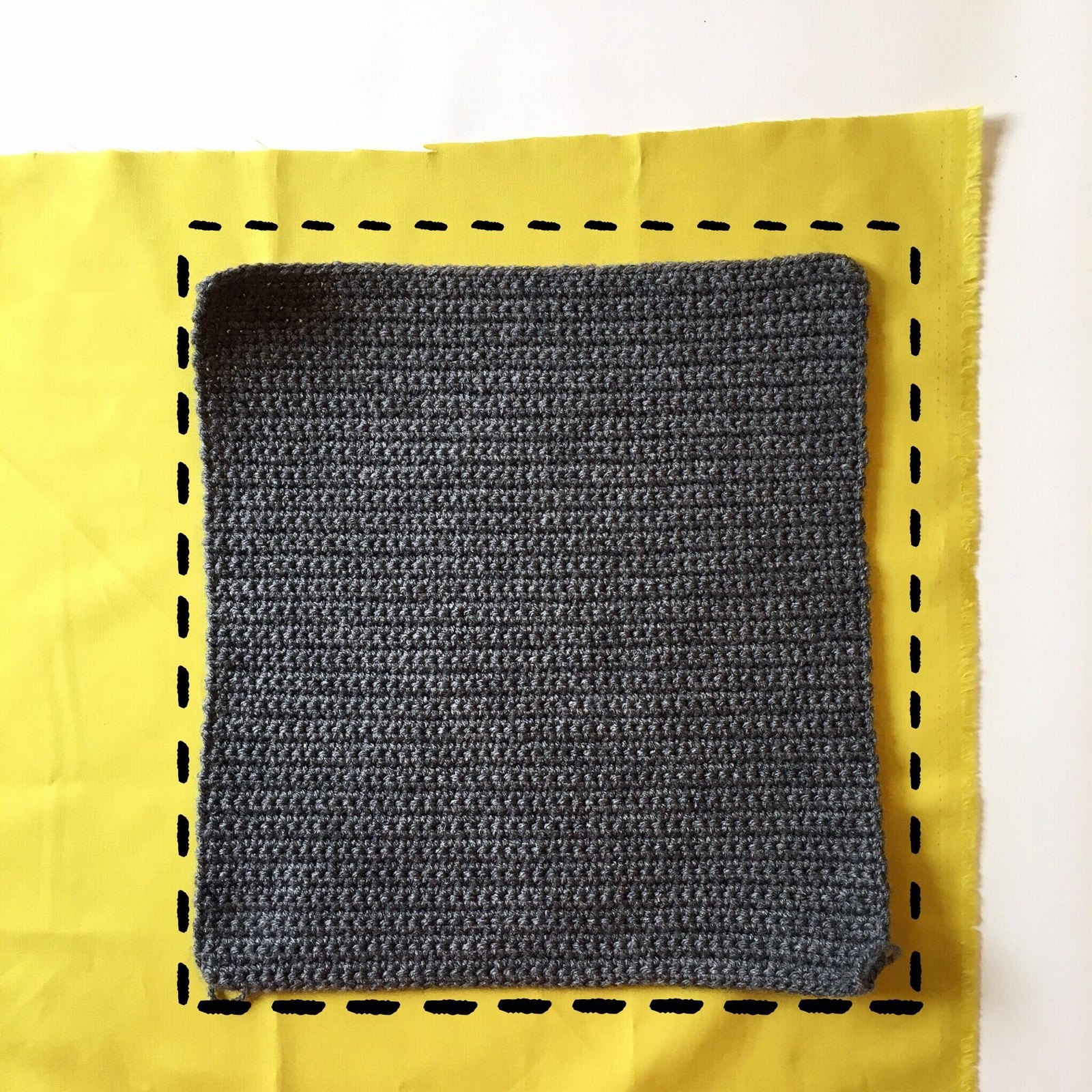 Grey crochet panel lying on fabric