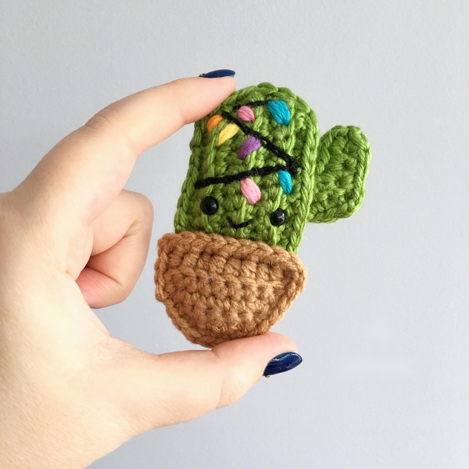 Hand holding crochet cactus ornament