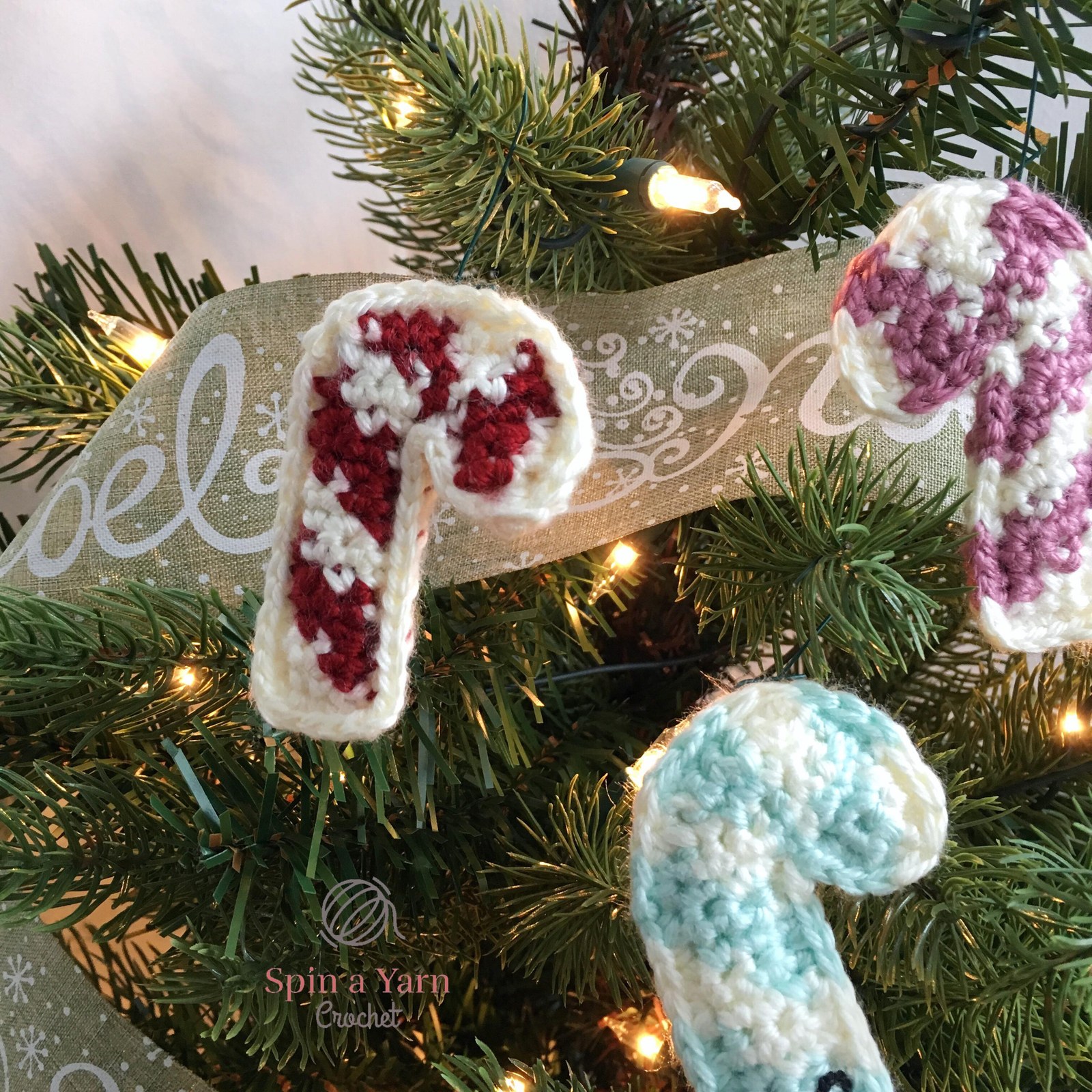 Three crochet candy canes on tree
