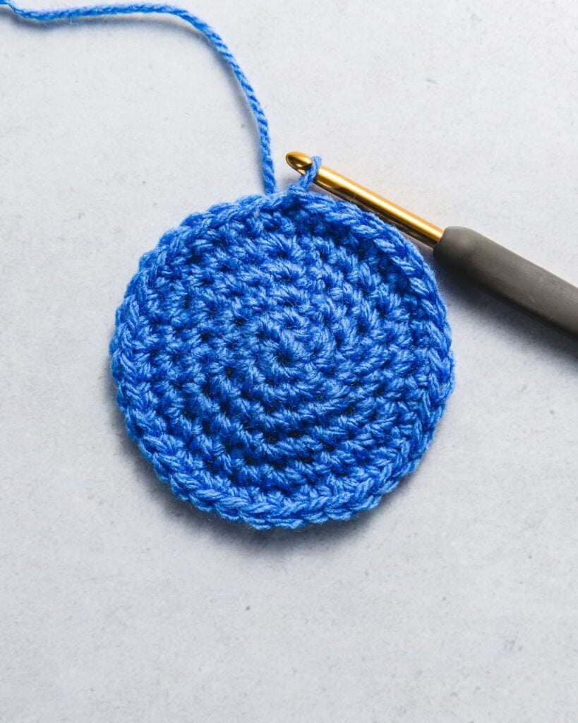 Perfect flat crochet circles in cotton yarn lying flat with tape measure and hook
