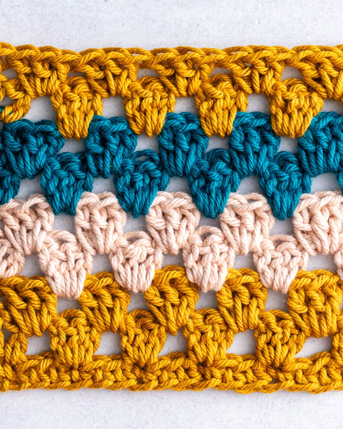 Colorful retro crochet granny stripe stitch blanket swatch in rainbow pastels