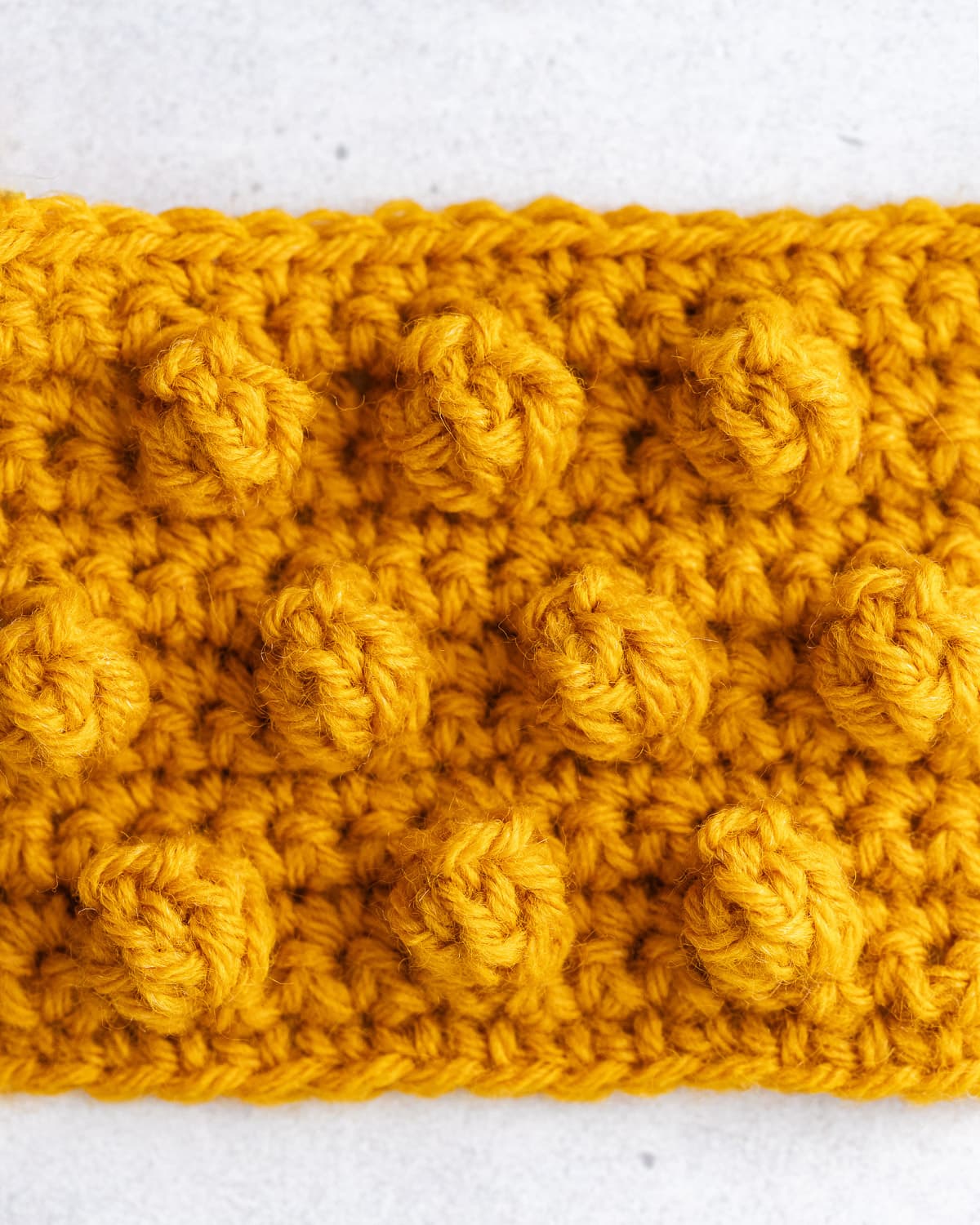 Finished popcorn stitch crochet fabric showing bold 3D rounded spherical popcorns