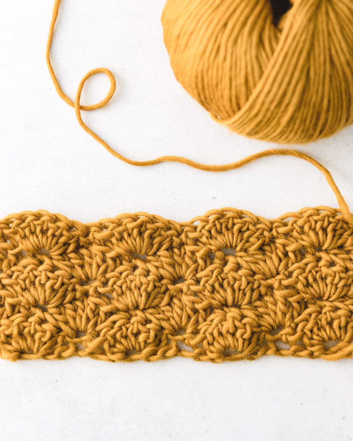 Close-up of pastel pink crochet shell stitch swatch with undulating fan waves