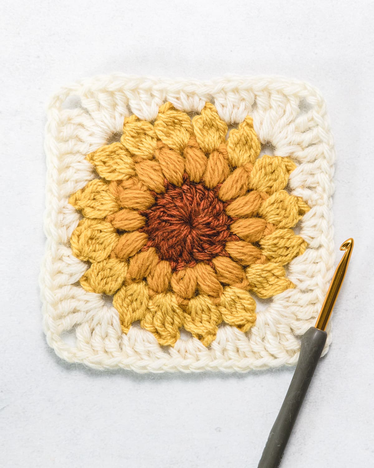 Four finished sunflower sunburst granny squares neatly arranged on rustic background