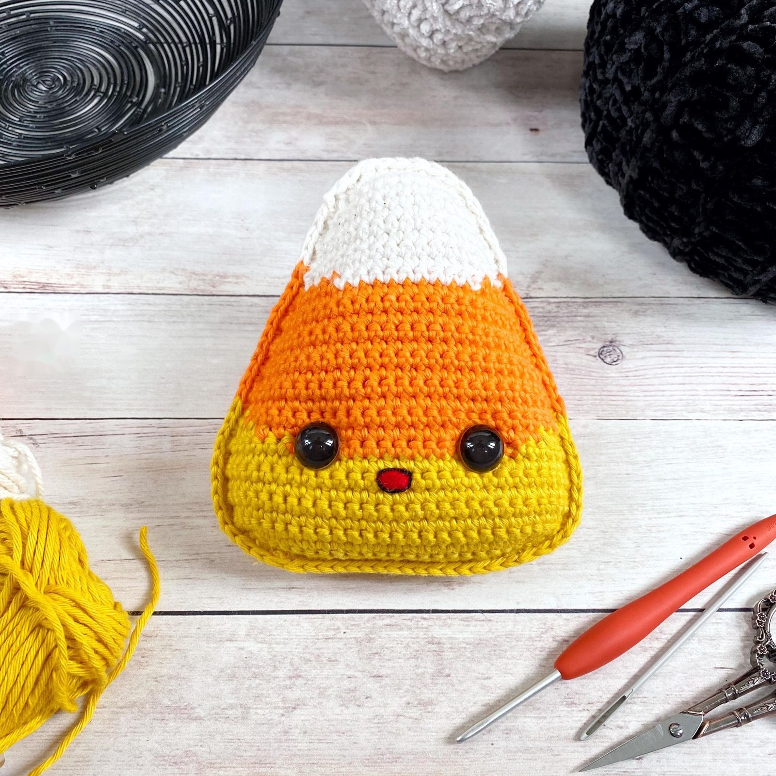 Finished kawaii candy corn crochet amigurumi with happy smile and rosy cheeks